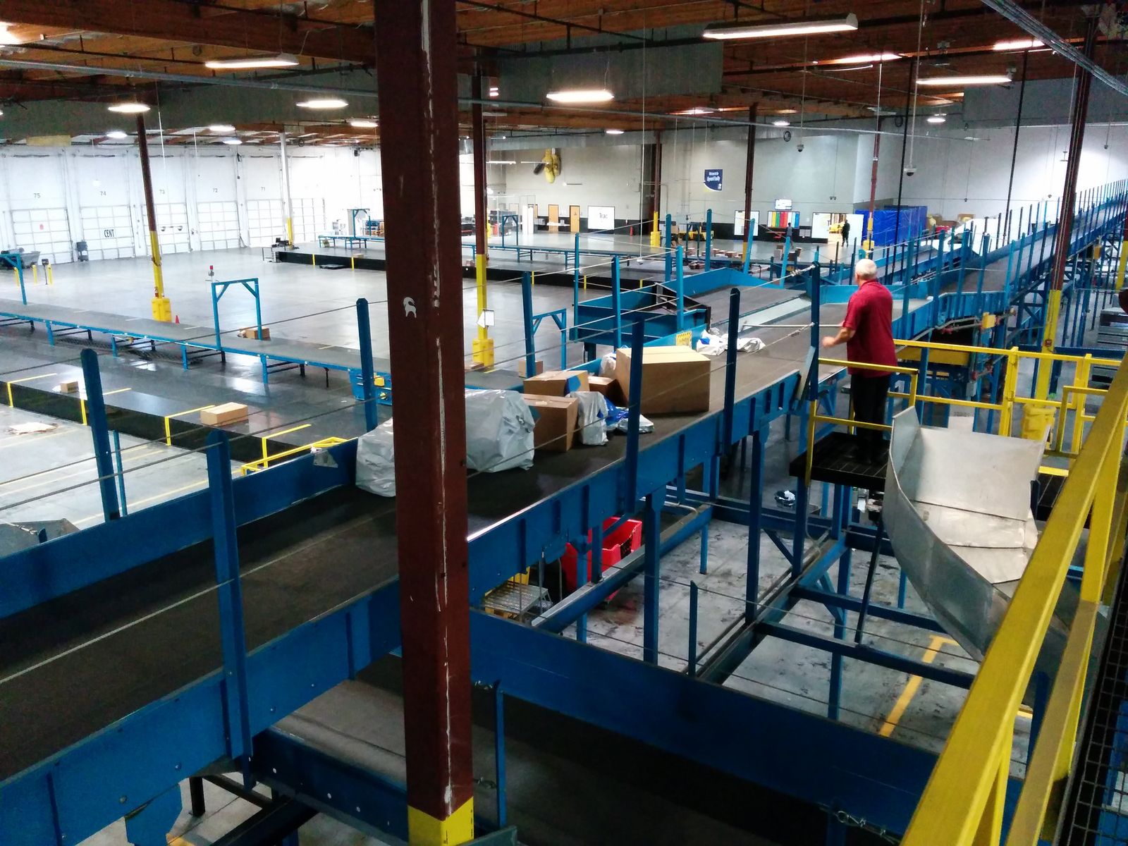A wide view of a fulfillment center sortation floor with blue conveyors